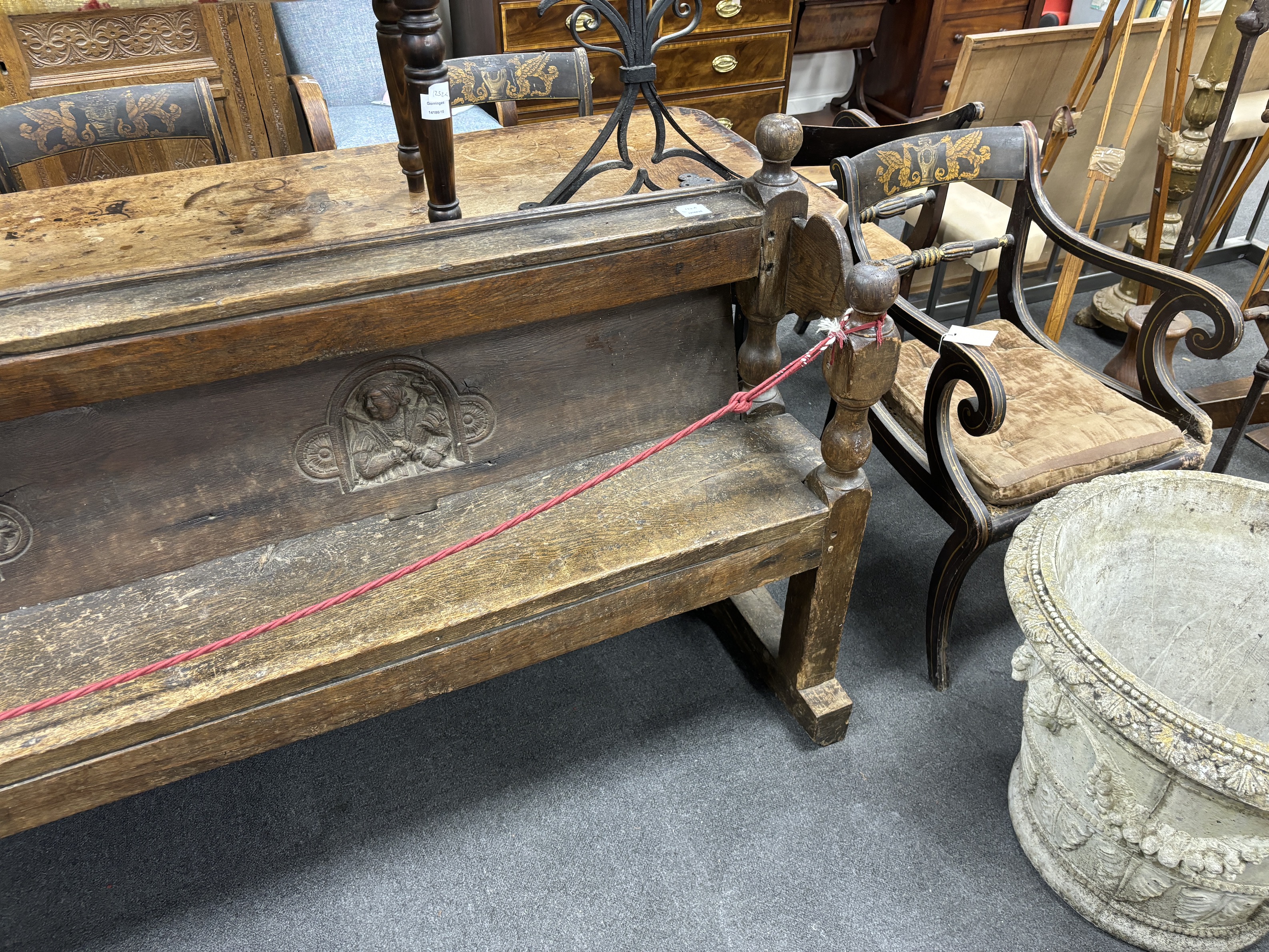 An oak pew, inset with three Romayne portrait panels, the panel possibly 16th century, width 220cm, depth 40cm, height 92cm, Provenance- Brede Place, East Sussex, a former residence of the Frewen family from 1712-1936.